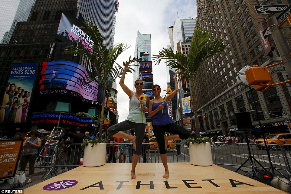 Women strike a pose  in Times Square as part of the summer solstice celebration of yoga