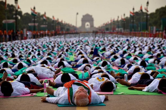 Indian Prime Minister Narendra Modi, center front, lies down on a mat as he performs yoga along with thousands of Indians on Rajpath, in New Delhi, India, Sunday, June 21, 2015. Millions of yoga enthusiasts are bending their bodies in complex postures across India as they take part in a mass yoga program to mark the first International Yoga Day. Photo: Saurabh Das, AP / AP