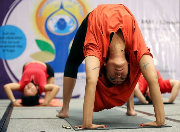 A Filipino yoga enthusiast performs a pose during the International Yoga Day inside a mall in suburban Taguig, south of Manila, Philippines on Sunday, June 21, 2015. Yoga enthusiasts bent and twisted their bodies in complex postures across India and much of the world on Sunday to mark the first International Yoga Day. Photo: Aaron Favila, AP / AP